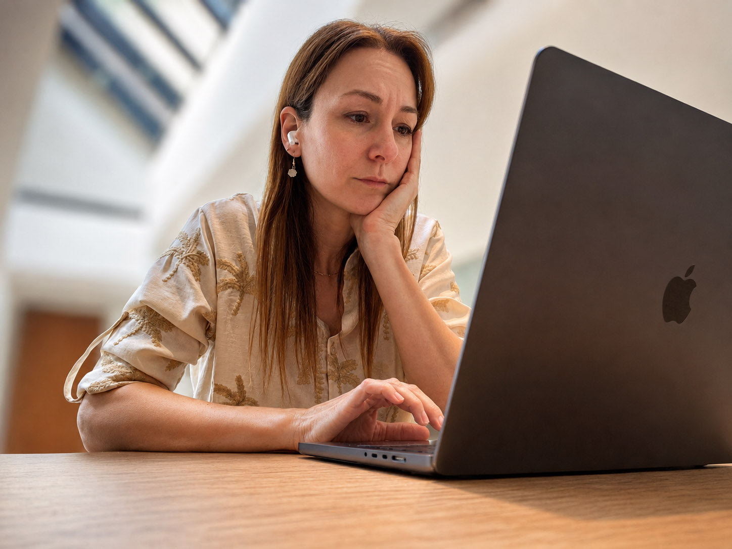 A professional woman at her desk, mid-thought